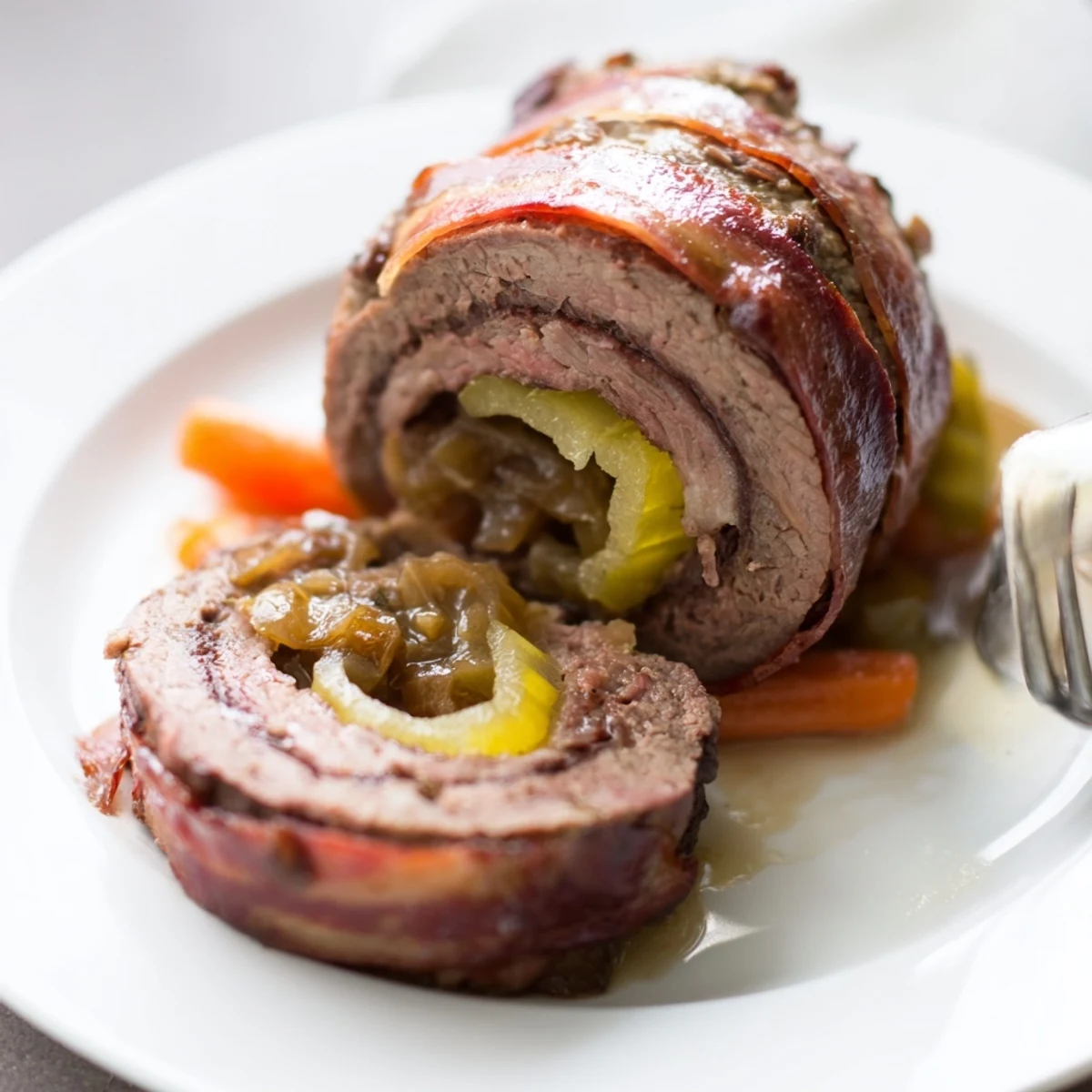 Saftige Rinderrouladen mit Zwiebeln, serviert mit Kartoffelknödeln und Gravy.